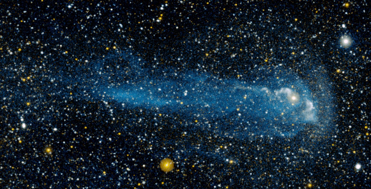 Imagen en ultravioleta de la estrella Mira: un punto brillante rodeado de un bulbo pálido en el lado derecho del encuadre, del que sale hacia la izquierda una larga estela azulada con forma de cola de cometa, sobre un fondo sembrado de estrellas blancas y amarillas.